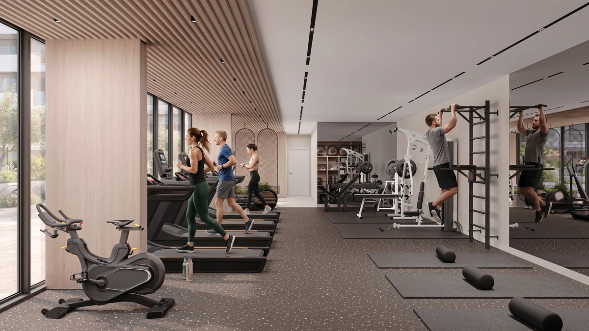 Residents exercising in the equipped gym with cardio machines and strength training areas.