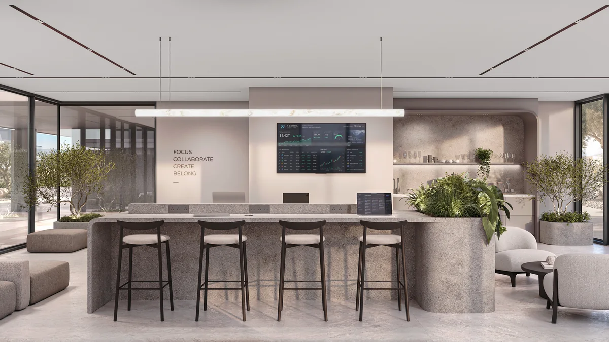 Shared coworking desk with bar stools, pendant lighting and a wall display.